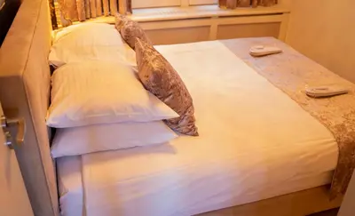 a bed with white pillows and a window at Dutch Masters Short Stay Apartments in Amsterdam