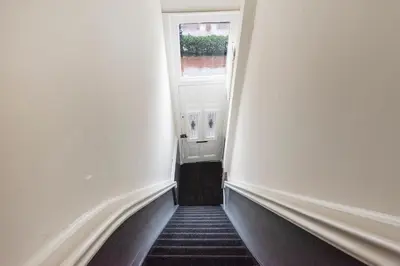 a hallway with a door and a window and stairs at Spaarne Luxury Residence Haarlem in Haarlem