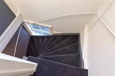 a spiral staircase in a house with a window at Spaarne Luxury Residence Haarlem in Haarlem
