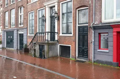 a wet street with buildings on a rainy at Spaarne Luxury Residence Haarlem in Haarlem