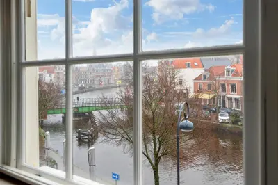 a window with a view of a river and a bridge at Spaarne Luxury Residence Haarlem in Haarlem