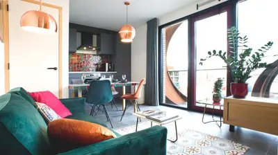 a living room with a green couch and a table at Huis met de krul in Amsterdam