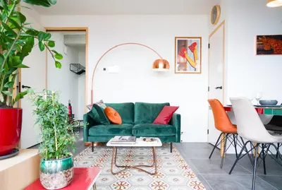 a living room with a green couch and a table at Huis met de krul in Amsterdam