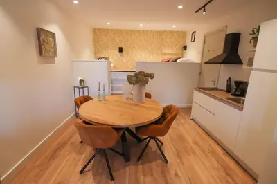 a kitchen with a wooden table and chairs in a kitchen at Volendam Lakeside Retreat - 20 min from Amsterdam in Volendam