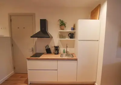 a kitchen with a white refrigerator and a sink at Volendam Lakeside Retreat - 20 min from Amsterdam in Volendam