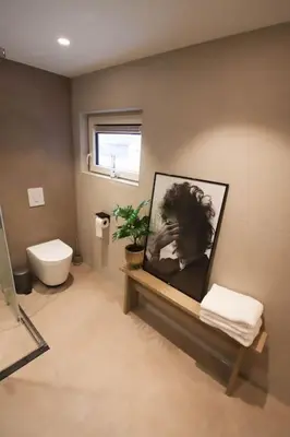 a bathroom with a toilet and a picture on the wall at Volendam Lakeside Retreat - 20 min from Amsterdam in Volendam