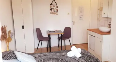 a small kitchen with a table and two chairs in a room at Pension Zandvoort aan Zee in Zandvoort