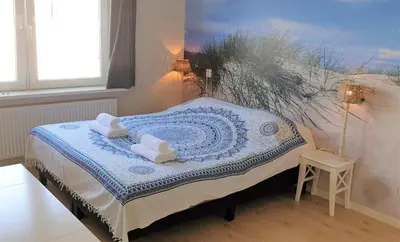 a bedroom with a bed with two towels on it at Pension Zandvoort aan Zee in Zandvoort