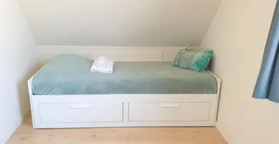 a small bed in a corner of a room at Pension Zandvoort aan Zee in Zandvoort