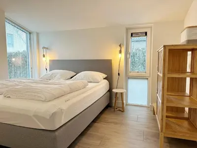 a bedroom with a large bed with white sheets at Bungalow 57 op Recreatiepark De Wielen in Sint Maarten