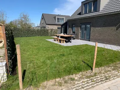 a backyard with a picnic table and a fence at Bungalow 57 op Recreatiepark De Wielen in Sint Maarten