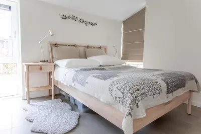 a bedroom with a large bed and a table at Bungalow 68 op Recreatiepark De Wielen in Sint Maarten