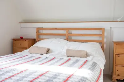 a bedroom with a bed with two pillows on it at Bungalow 68 op Recreatiepark De Wielen in Sint Maarten