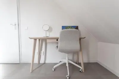 a desk with a chair next to a table with a mirror at Bungalow 68 op Recreatiepark De Wielen in Sint Maarten