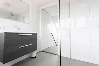 a bathroom with a sink and a glass shower at Bungalow 68 op Recreatiepark De Wielen in Sint Maarten