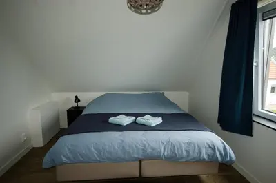 a bedroom with a bed with two towels on it at Bungalow 70 op Recreatiepark De Wielen in Sint Maarten