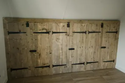 a wooden barn door in the corner of a room at Bungalow 70 op Recreatiepark De Wielen in Sint Maarten