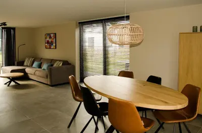 a living room with a wooden table and chairs at Bungalow 70 op Recreatiepark De Wielen in Sint Maarten