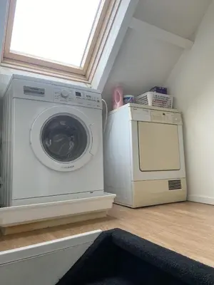 a laundry room with a washing machine and a window at Appartement Twins in Wijk aan Zee