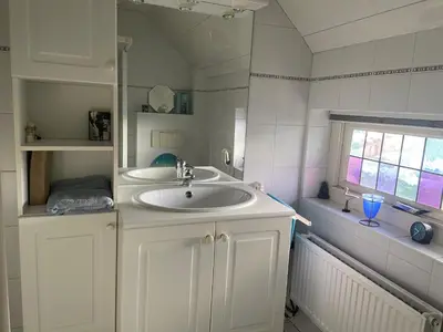 a white bathroom with a sink and a window at Appartement Twins in Wijk aan Zee