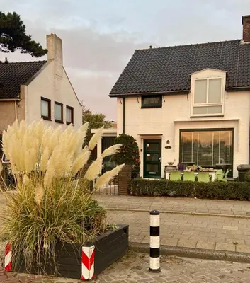 a white house with a black roof at Appartement Twins in Wijk aan Zee