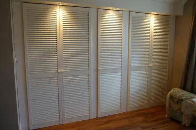 a room with white closet doors with a bed at Golden Wellness Villa Noordwijk in Noordwijk