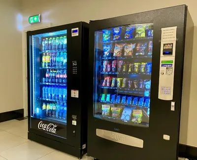 two soda machines in a store with drinks in them at XO Hotels Blue Tower in Amsterdam