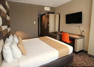 a hotel room with a bed and a desk with a computer at XO Hotels Blue Tower in Amsterdam