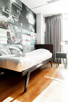 a bed in a room with a wall with pictures at Qbic Amsterdam WTC in Amsterdam
