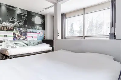 a bedroom with two beds and a window at Qbic Amsterdam WTC in Amsterdam