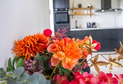a vase filled with colorful flowers in a kitchen at Veldt's huisje in Limmen