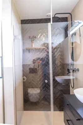 a bathroom with a shower with a toilet and a sink at Veldt's huisje in Limmen