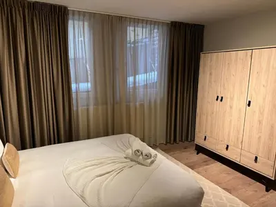 a bedroom with a white bed and a large window at High Street Apartments in Zandvoort