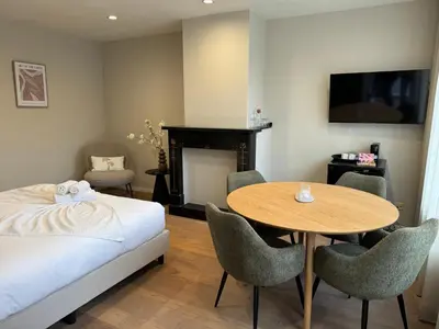 a bedroom with a bed and a table and chairs at High Street Apartments in Zandvoort