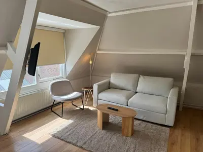 a living room with a couch and a table at High Street Apartments in Zandvoort
