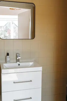 a bathroom with a white sink and a mirror at High Street Apartments in Zandvoort