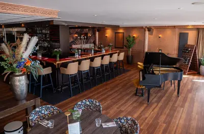 a bar in a restaurant with chairs and tables at Heeren van Noortwyck in Noordwijk aan Zee