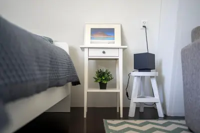 a bedroom with a bed and a table with a night stand at Your own floor in authentic picturesque dikehouse - dijkhuis181 in Amsterdam