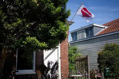 a cocacola flag flying in front of a house at Your own floor in authentic picturesque dikehouse - dijkhuis181 in Amsterdam