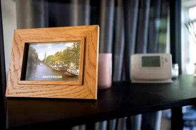 a wooden picture frame sitting on a table with a clock at Your own floor in authentic picturesque dikehouse - dijkhuis181 in Amsterdam