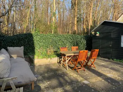a patio with a table and chairs and a fence at Holiday Home near Noordwijk Beach in Noordwijkerhout