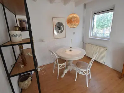 a dining room with a white table and chairs at Holiday Home near Noordwijk Beach in Noordwijkerhout