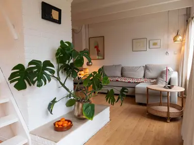 a living room with a couch and a plant at Holiday Home near Noordwijk Beach in Noordwijkerhout