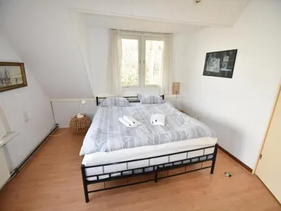 a bedroom with a bed with two towels on it at Holiday Home near Noordwijk Beach in Noordwijkerhout