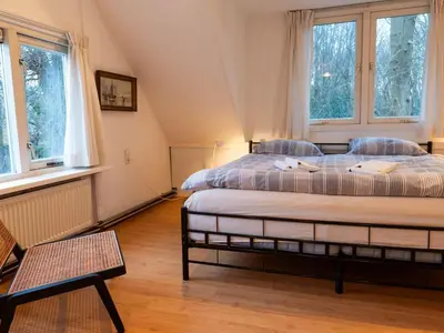 a bedroom with two beds and two windows at Holiday Home near Noordwijk Beach in Noordwijkerhout