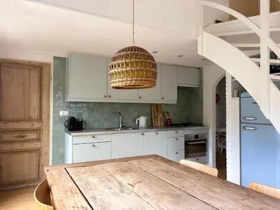 a kitchen with a wooden table and a chandelier at Holiday Home near Noordwijk Beach in Noordwijkerhout