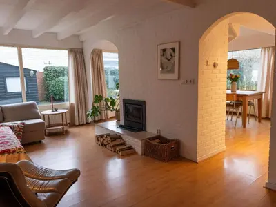 a living room with a fireplace and a couch at Holiday Home near Noordwijk Beach in Noordwijkerhout