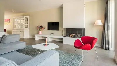 a living room with a couch and a red chair at Casa Jill in Bergen