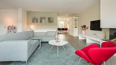a living room with a couch and red chairs at Casa Jill in Bergen