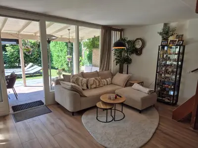 a living room with a couch and a table at Bungalow 15 op Recreatiepark De Wielen in Sint Maarten